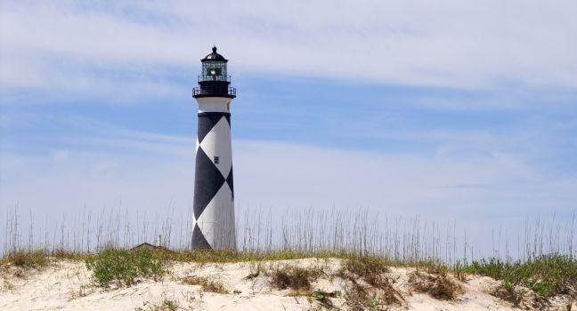 A historic lighthouse guiding ships away from rocky shoals.