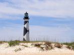 A historic lighthouse guiding ships away from rocky shoals.