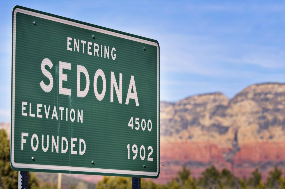 Entering Sedona Arizona, USA, road sign with red rock mountains visible in background.; Shutterstock ID 68866102; Project/Title: Fodors; Downloader: Melanie Marin