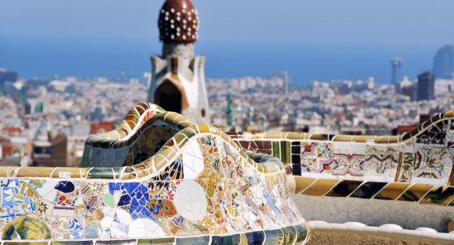 Bench in the Park Guell on July 11, 2011 in Barcelona, Spain. Famous park designed by Antoni Gaudi with a view at the city and sea. UNESCO World Heritage Site.