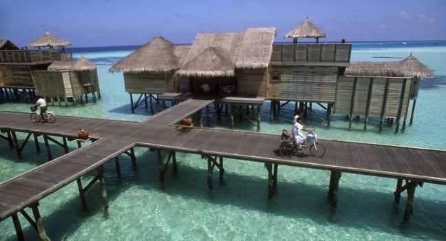 At Soneva Gilu, bicycling posters criss-cross the elevated boardwalk intersections amongst a remarkable assemblage of rustic villas, stilted above the Indian Ocean's turqouise lagoons.  Kunfunadhoo Island, Baa Atoll, Maldives