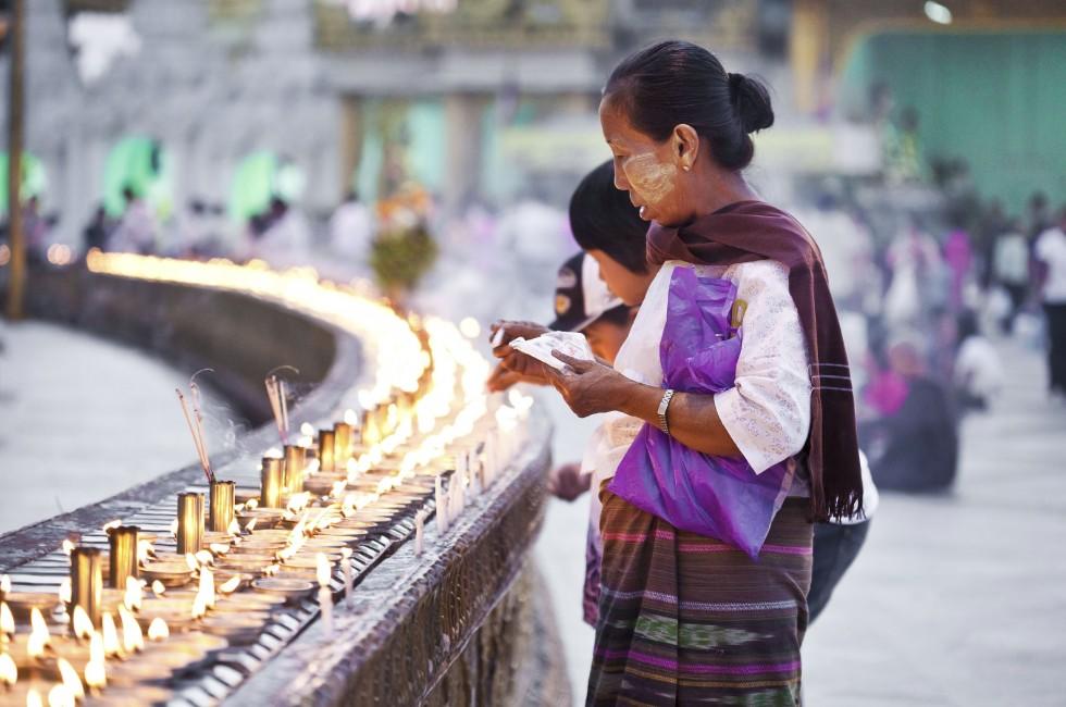 YANGON, MYANMAR - JAN 31: Buddhist devotees lighting candles at the full moon festival, Shwedagon Pagoda, January 31, 2010 in Myanmar (Burma).