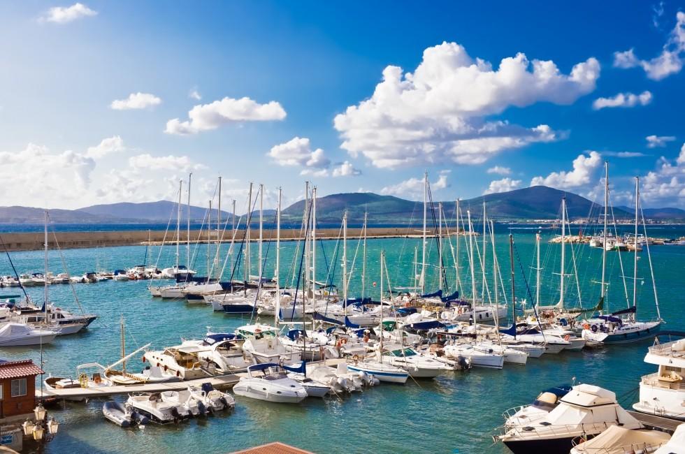 Classic white yachts anchored in the port of Alghero, Sardinia; 