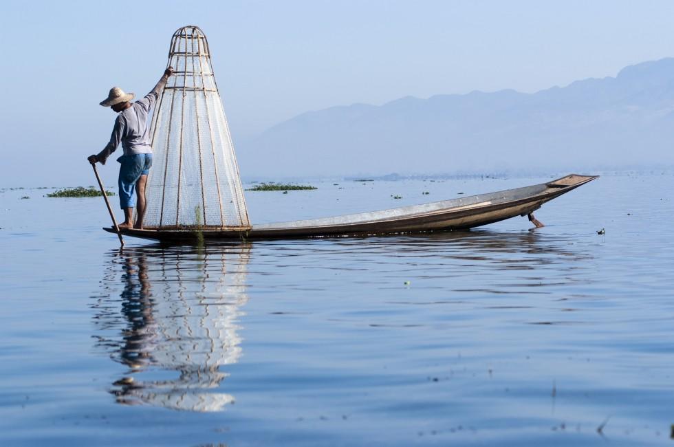 INLE LAKE, MYANMAR - FEBRUARY 17: Fisherman catches fish for food on February 17, 2011 on Inle Lake, Myanmar. Intha people possess the leg-rowing style and the  unique coop-like fishing equipment.